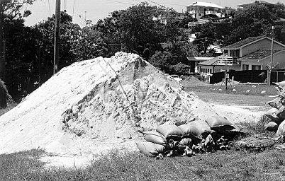 A sandpile waiting to be used in road construction works spreading unto the road