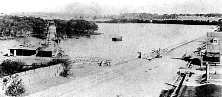 Looking south over the Cooks River Dam, 1870. A lime-burning kiln stands on the left. The dam had been built by a hundred convicts in 1840. The Cooks River now runs beside the Airport runways. It is a tributary of Botany Bay. (Photo: Sutherland Library)